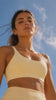 Woman outdoors in yellow athleisure in the sunlight as part of the GoSol Daily skin support routine.